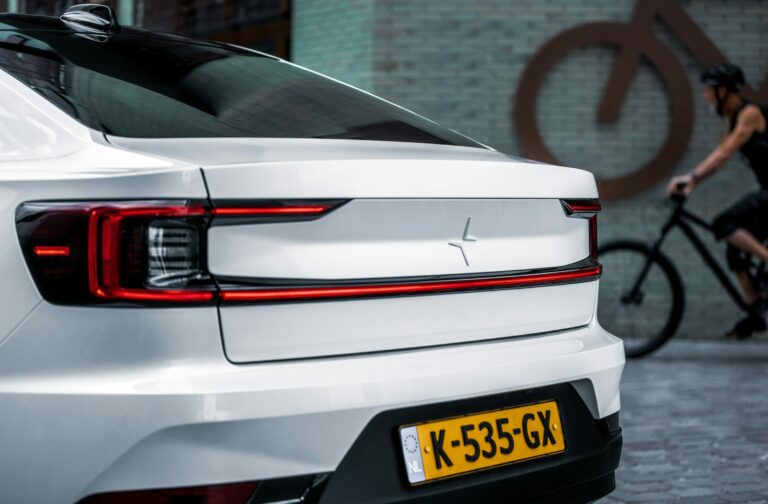 Electric vehicle driving in a city street, global EV adoption