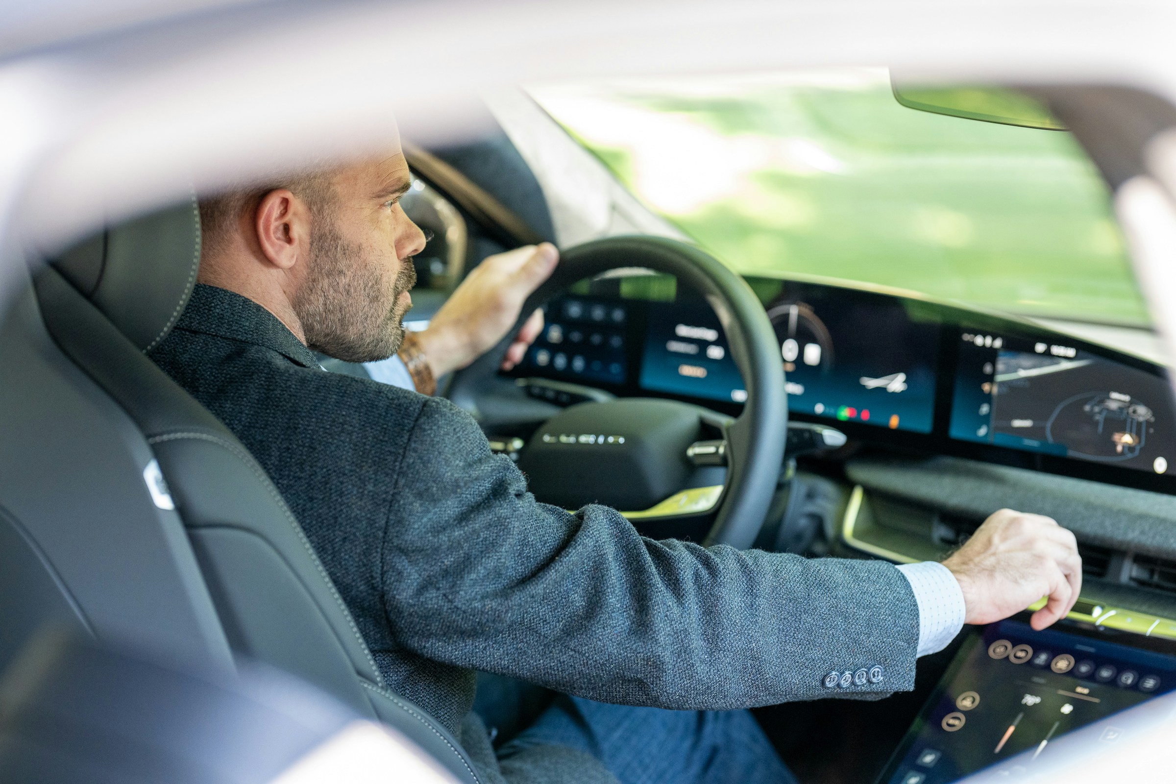 Man driving an electric car in France, seen from behind