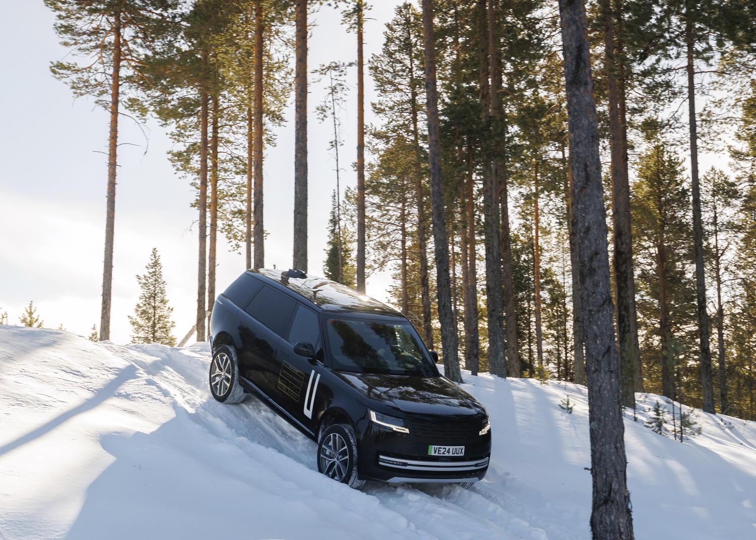 Range Rover Electric front view of a frozen snowy lake, 100% electric luxury SUV