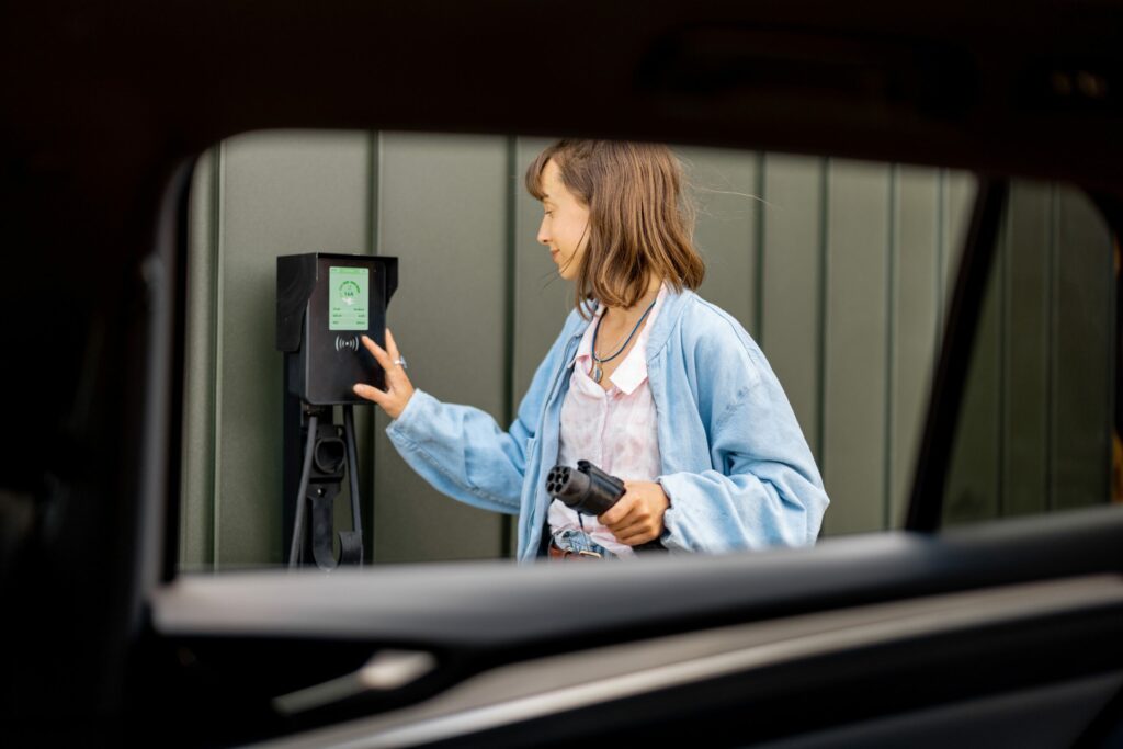Woman charging her electric car at home