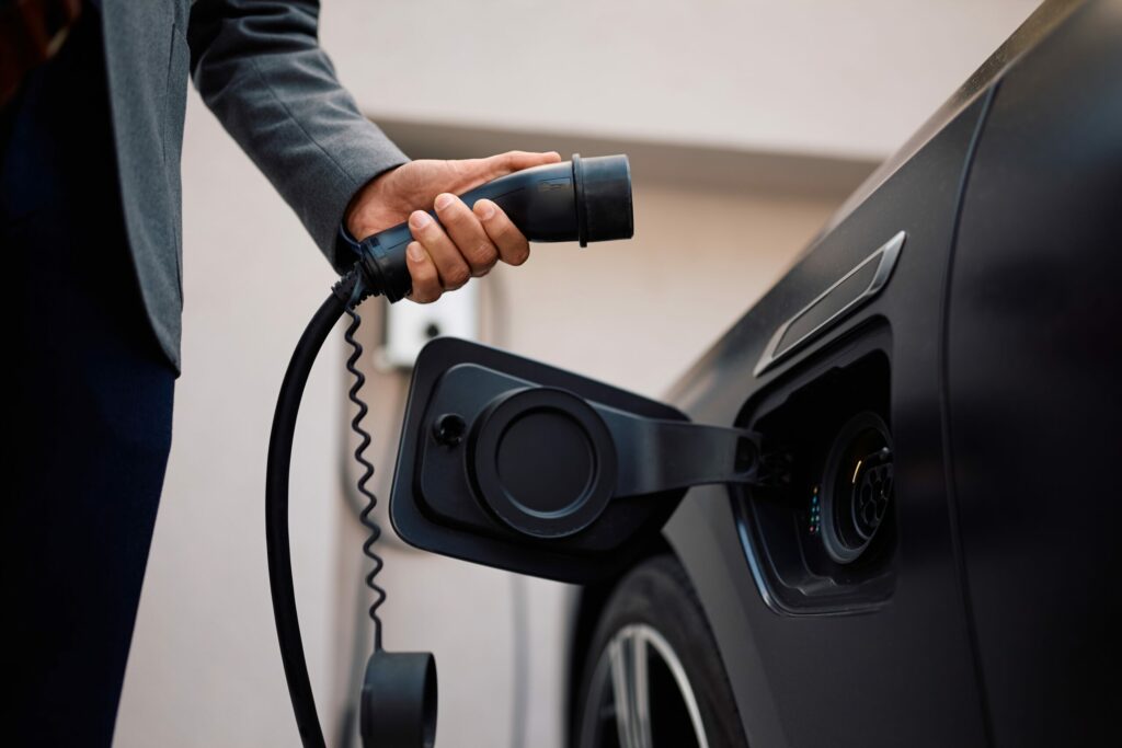 Plugging in a cable to charge an electric car
