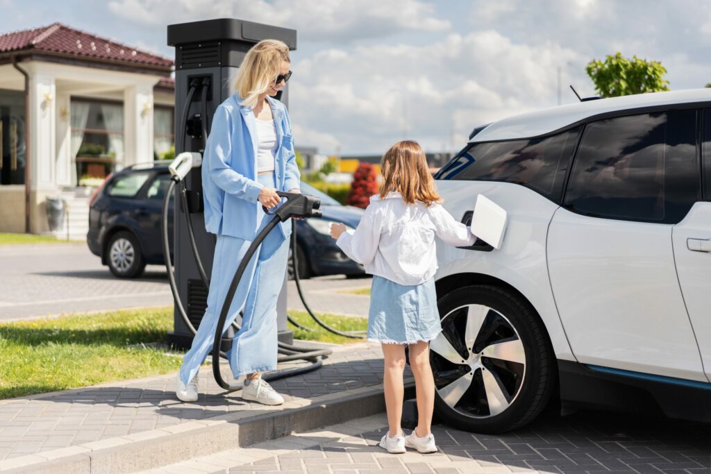 Mère et fille connectant leur voiture électrique à une borne