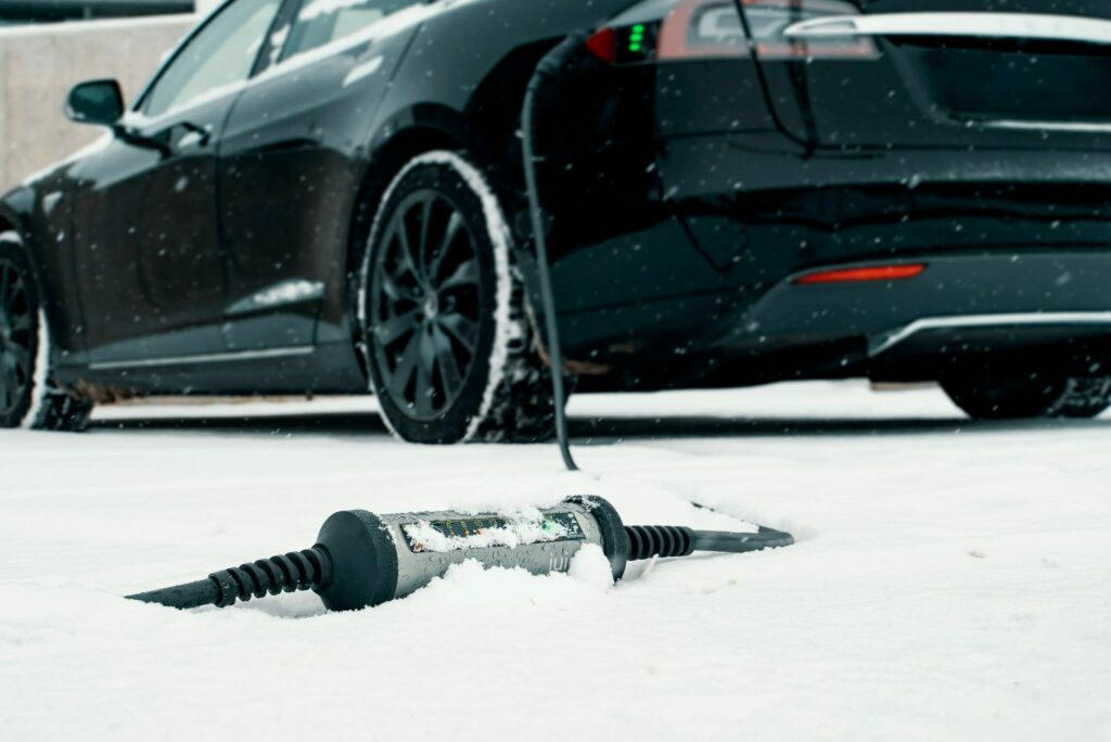 Electric car charging under the snow in winter