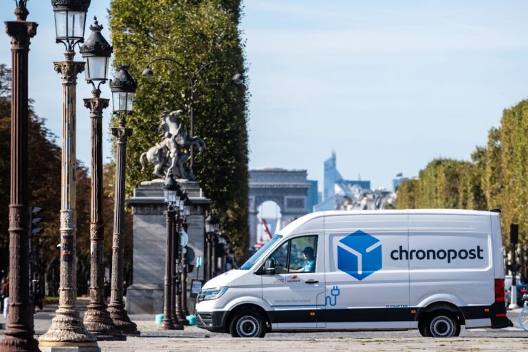 Camionnette Chronopost électrique de profil circulant sur les Champs-Élysées