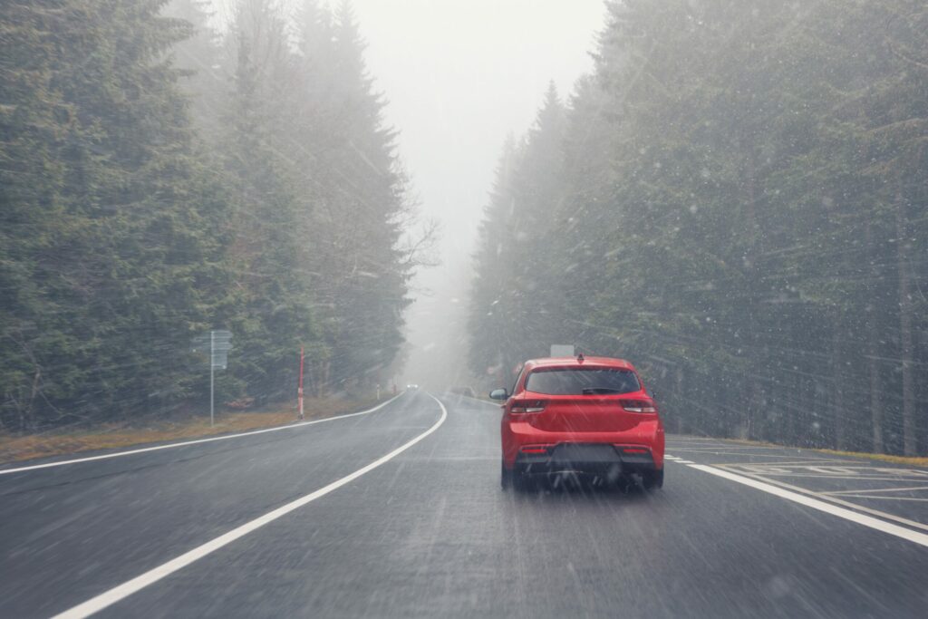 Snow-covered motorway in the mountains with cars travelling in difficult winter conditions