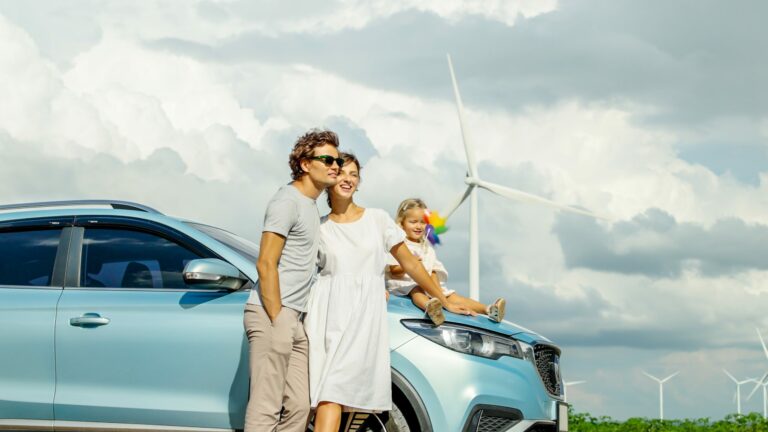 Happy family in front of an electric car