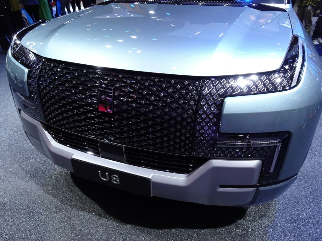 Gros plan sur la large calandre noire à motifs diamantés et le logo du YangWang U8. Source : Wikimedia Commons